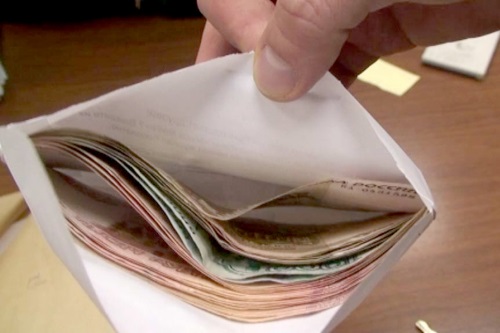 Изображение денежных средств в конверте чиновника